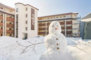 un muñeco de nieve frente a un edificio en Reka-Feriendorf Sörenberg, en Sörenberg