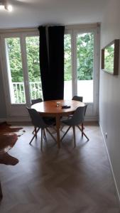 - une salle à manger avec une table et des chaises en bois dans l'établissement Le Mangin - Rent4night Grenoble, à Grenoble
