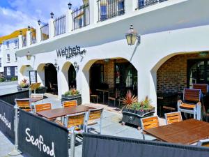 a restaurant with tables and chairs in front of a building at Hastings Old Town Tackleway privileged Sea Views whole house 3 beds in Hastings