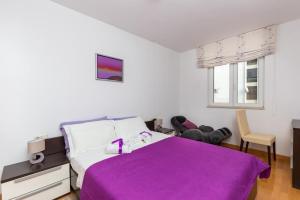 a bedroom with a bed with a purple blanket at Apartment Buby in Dubrovnik