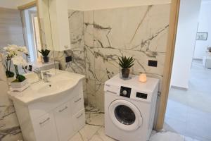 a bathroom with a washing machine and a sink at Toto Residence in Torre Lapillo