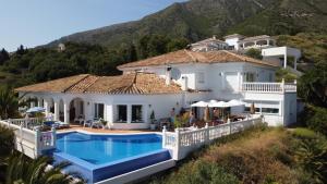 a house with a swimming pool in front of a mountain at Villa Mañana in Mijas