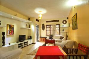 un soggiorno con divano e TV di Remarkable 2-Bed Cottage Along Gayaza road a Kampala