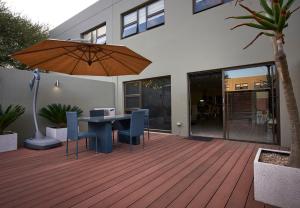 a patio with a table and chairs and an umbrella at Dynasty Forest Sandown Serviced Apartments & Self Catering Hotel in Johannesburg