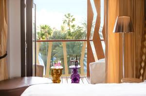 Schlafzimmer mit einem Fenster mit Blick auf Palmen in der Unterkunft Bohemia Suites & Spa - Adults Only in Playa del Ingles