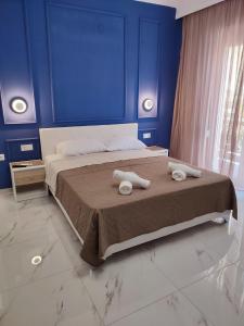 a blue bedroom with a bed with two towels on it at JOY HOME in Kavála