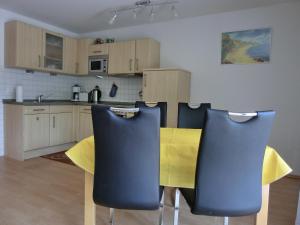 una cucina con sedie gialle e blu in una stanza di Ferienwohnung U2 a Graal-Müritz
