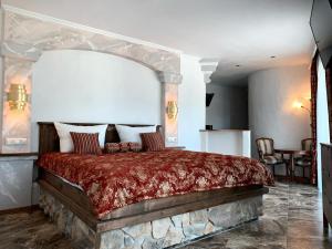 a bedroom with a large bed with a red blanket at Resort Hanni Deisenberger in Fieberbrunn
