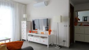 a living room with a television on a white dresser at Sotavento Las Terrazas II, La Tejita in La Tejita