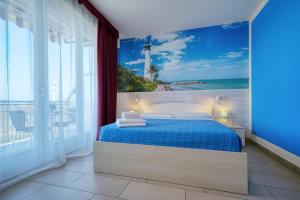 a bedroom with a blue bed with a view of the ocean at The Lighthouse Rooms in Lazise