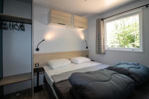 クー・エ・ビガロックにあるCamping le Clouの小さなベッドルーム(ベッド2台、窓付)