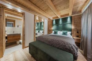 a bedroom with a large bed and a bathroom at Chalet Socrepes - Dolomiti Skyline in Cortina dʼAmpezzo