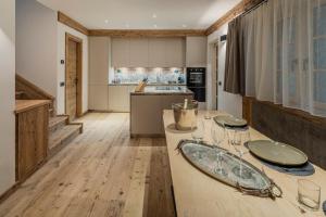 a kitchen with a table with wine glasses on it at Chalet Socrepes - Dolomiti Skyline in Cortina dʼAmpezzo