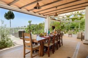 an outdoor dining room with a wooden table and chairs at Villa Armonía in San Antonio