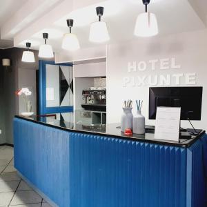 vestíbulo del hotel con mostrador de recepción azul en Hotel Pixunte en Policastro Bussentino