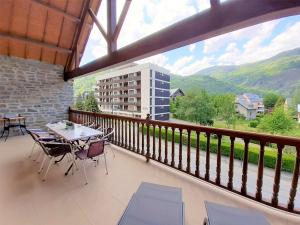 a balcony with a table and chairs and a building at Appartement Saint-Lary-Soulan, 3 pièces, 8 personnes - FR-1-457-183 in Saint-Lary-Soulan