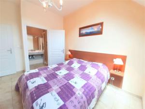 1 Schlafzimmer mit einem lila Bett und einem Badezimmer in der Unterkunft Appartement Saint-Lary-Soulan, 3 pièces, 8 personnes - FR-1-457-183 in Saint-Lary-Soulan