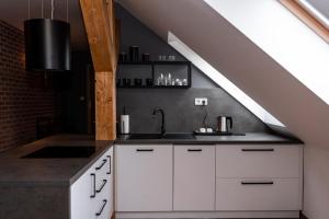 a kitchen with white cabinets and a sink at PARKHOUSE in Rožňava