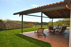 a patio with a table and chairs under a pavilion at RED ROSES appartamento al piano terra in villa in Itri