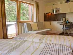 a bedroom with a bed and a living room with a kitchen at Apartment Urgbach Apart-1 by Interhome in Landeck