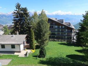 Blick auf ein Gebäude mit Bergen im Hintergrund in der Unterkunft Apartment Montfort 9A by Interhome in Nendaz