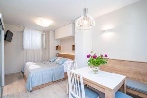 Cette petite chambre comprend un lit et une table fleurie. dans l'établissement Studio apartment Lapad, à Dubrovnik