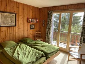sypialnia z łóżkiem i dużym oknem w obiekcie Chalet L'Alpage by Interhome w mieście Ovronnaz