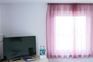 a television sitting on a table in front of a window at Hotel Albblick Bad Boll in Bad Boll