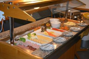 una línea de buffet con muchos tipos diferentes de comida en Hotel Albblick Bad Boll, en Bad Boll
