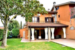 a house with white curtains on the front of it at La Luna sul lago in Trevignano Romano