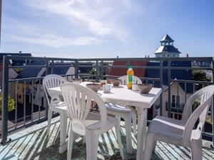 d'une table et de chaises blanches sur un balcon. dans l'établissement Apartment Port Guillaume-6 by Interhome, à Cabourg