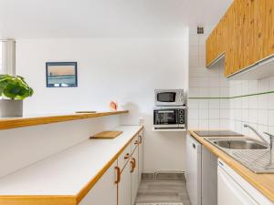 a kitchen with a sink and a microwave at Apartment Les Maisons de l'Océan-7 by Interhome in Lacanau-Océan +29 photos