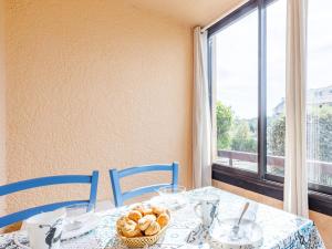 uma mesa com cadeiras azuis e um prato de pão em Apartment Les Maisons de l'Océan-7 by Interhome em Lacanau-Océan