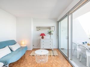- un salon avec un canapé bleu et une table dans l'établissement Apartment Les Arpèges-4 by Interhome, au Grau-du-Roi