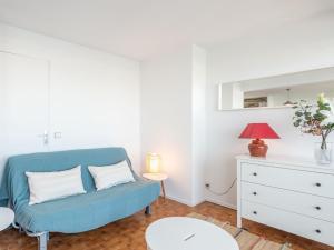 - un salon avec un canapé bleu et une commode dans l'établissement Apartment Les Arpèges-4 by Interhome, au Grau-du-Roi