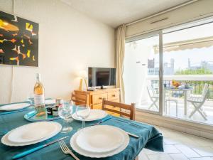 a dining room with a table with two plates on it at Studio Ulysse Plage-9 by Interhome in La Grande Motte