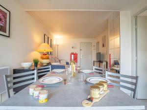 a dining room with a table with plates on it at Apartment Terrasses de la Baronnie-3 by Interhome in Le Grau-du-Roi