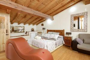 1 dormitorio con 1 cama y 1 silla en El Colirrojo - Los Sitios de Aravalle, en Casas del Abad