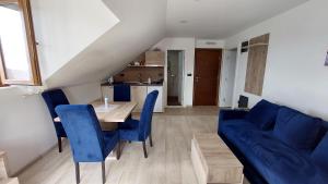 a living room with a table and a blue couch at Ctrl Alt Del Apartment S76 in Kopaonik