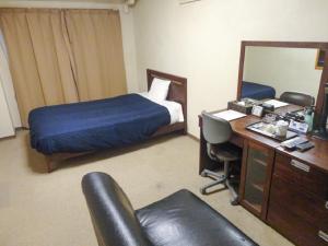 a hotel room with a bed and a desk with a computer at HOTEL LiVEMAX BUDGET Nagoya in Nagoya