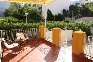 patio z krzesłami, stołem i ogrodzeniem w obiekcie Casa Galisa w mieście Torrevieja