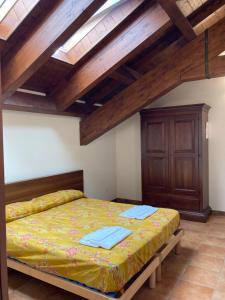 Agriturismo Altana Del Motto Rosso في Gattico: غرفة نوم بسرير في غرفة بسقوف خشبية