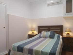sypialnia z łóżkiem z dwoma szafkami nocnymi i dwiema lampami w obiekcie Casa Galisa w mieście Torrevieja