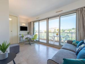a living room with a couch and a table at Studio Le Floriana by Interhome in Cannes