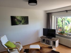 a living room with a flat screen tv next to a window at Ferienwohnung Kraichgaublick in Angelbachtal