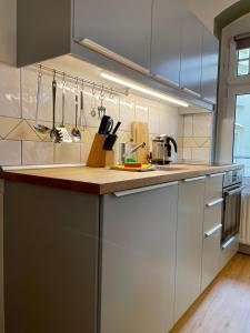 a kitchen with white cabinets and a wooden counter top at stadtRaum-berlin apartments in Berlin +21 photos