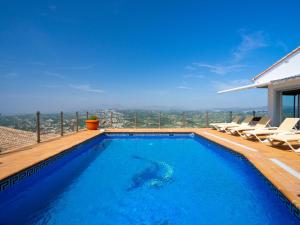a swimming pool with chairs and a view of the city at Holiday Home Stuttgart by Interhome in Cumbre del Sol