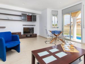 a living room with a blue couch and a table at Villa Plaza Hortensias by Interhome in Miami Platja