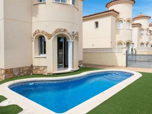 a villa with a swimming pool in front of a house at Villa Plaza Hortensias by Interhome in Miami Platja