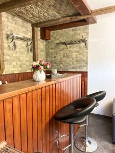 a bar with two stools and a vase of flowers at Chata Janik DUCHONKA in Duchonka